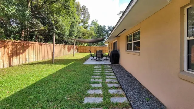 a view of backyard with table and chairs and wooden fence