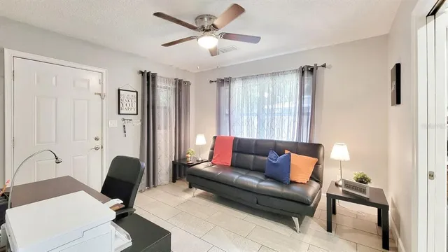 a living room with furniture a ceiling fan and a window
