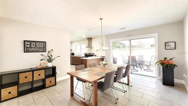 a kitchen with stainless steel appliances kitchen island granite countertop a table chairs and a view of living room