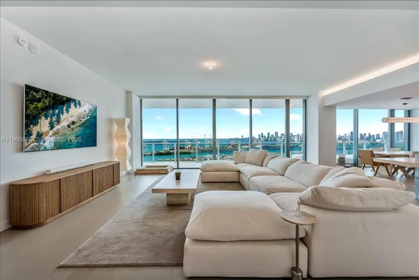 a living room with furniture large windows and a flat screen tv