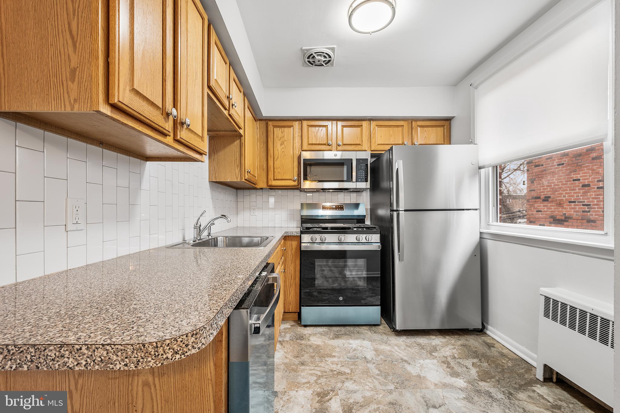 920 Durard Street Philadelphia, PA 19150 - Photo 6 of 16 a kitchen with granite countertop a refrigerator and a sink