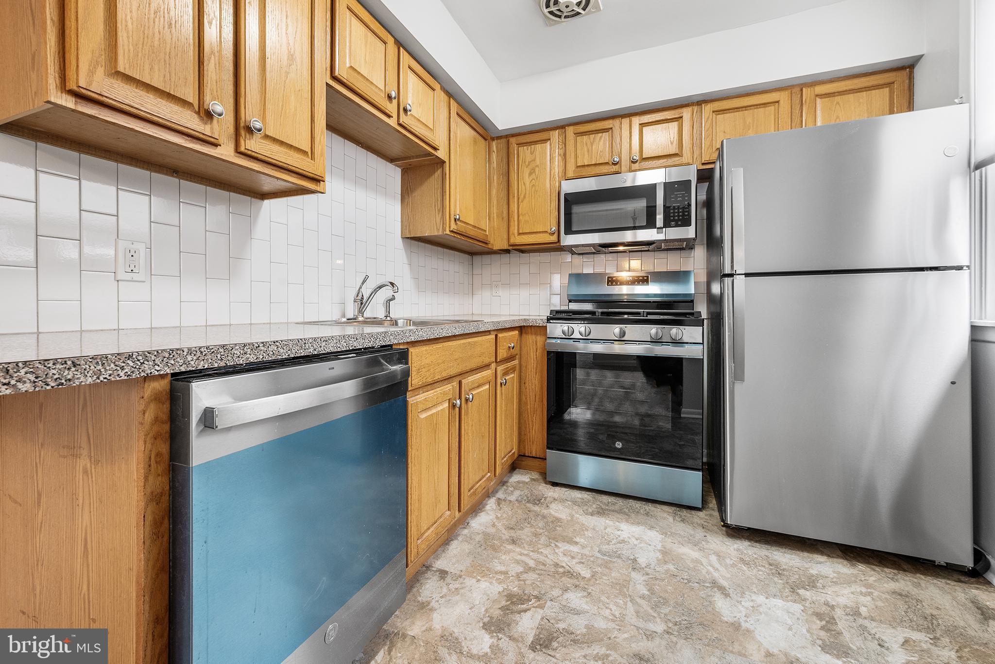 920 Durard Street Philadelphia, PA 19150 - Photo 7 of 16 a kitchen with stainless steel appliances granite countertop a refrigerator a stove a sink and a microwave