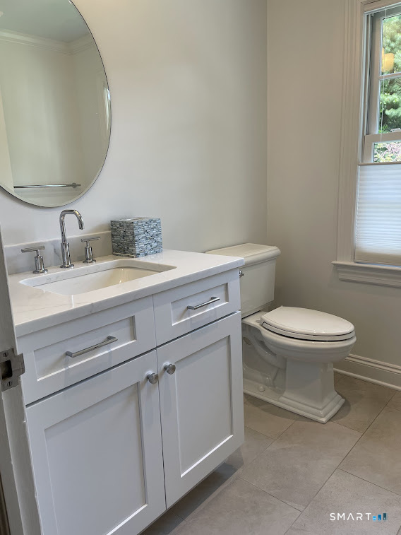 9 Tory Hole Road Darien, CT 06820 - Photo 22 of 33 a bathroom with a granite countertop toilet sink mirror and window