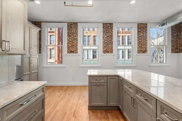 a kitchen with stainless steel appliances granite countertop a sink and wooden cabinets