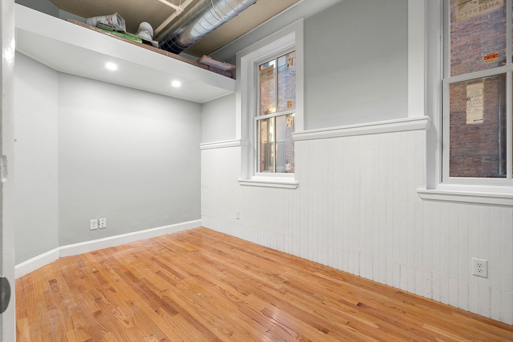 62 Washington Street, Unit 5 Haverhill, MA 01832 - Photo 17 of 34 an empty room with wooden floor and windows