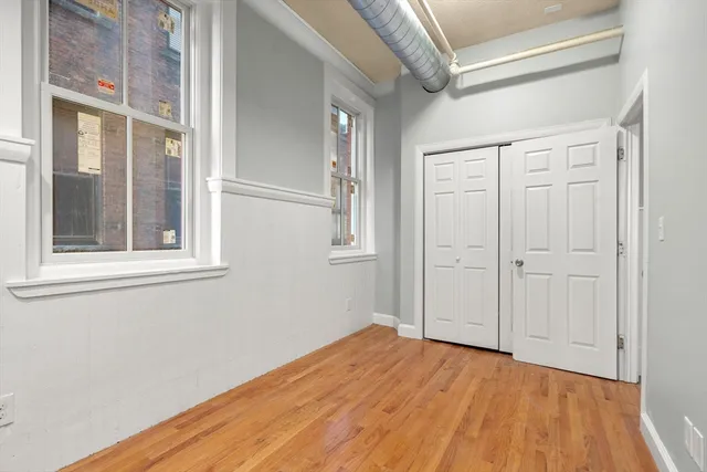 a view of empty room with wooden floor and entryway