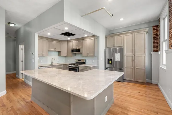 a kitchen with stainless steel appliances granite countertop a sink refrigerator and cabinets