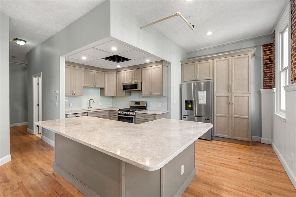 62 Washington Street, Unit 5 Haverhill, MA 01832 - Photo 2 of 34 a kitchen with stainless steel appliances granite countertop a sink refrigerator and cabinets
