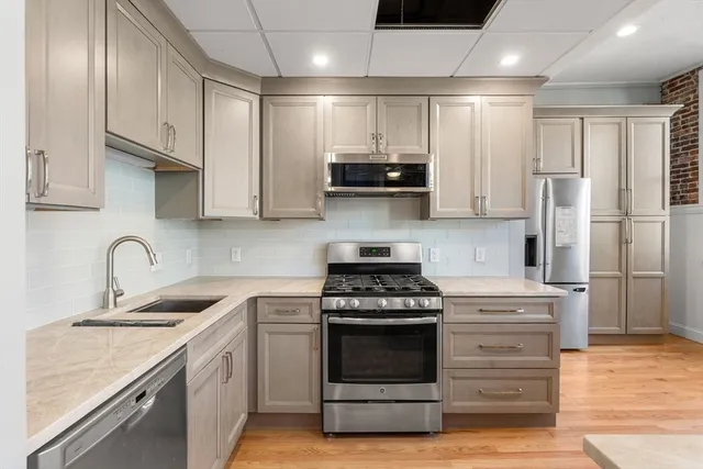 a kitchen with stainless steel appliances granite countertop a stove a sink and a refrigerator