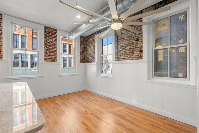 a view of empty room with wooden floor and fan