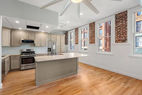 a large kitchen with stainless steel appliances granite countertop a stove and a sink