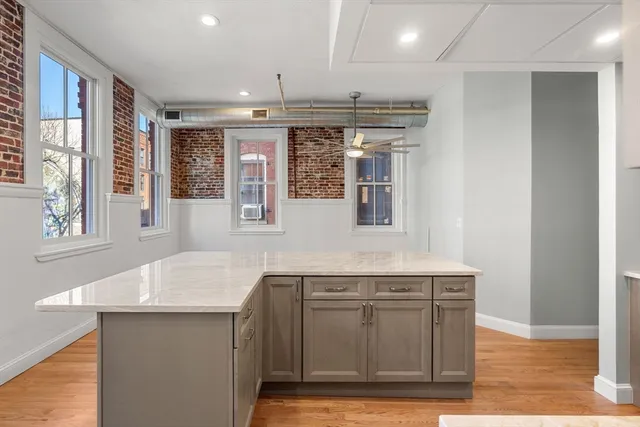a kitchen with stainless steel appliances granite countertop a sink and a wooden floor