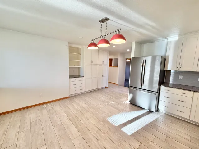 a view of a livingroom with wooden floor and stairs