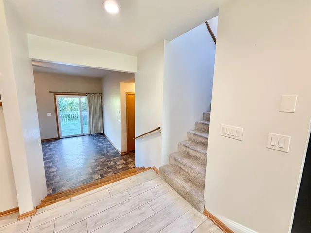 a view of an empty room with window and chandelier fan