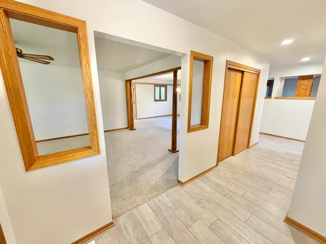 a view of a hallway with wooden floor and entryway