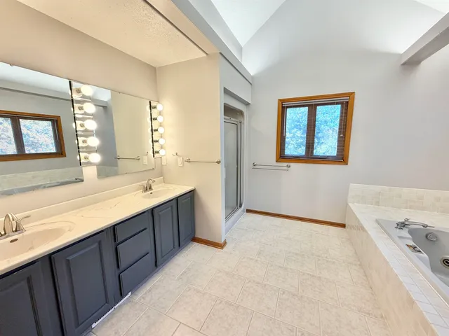 a view of an empty room with chandelier fan and wooden floor