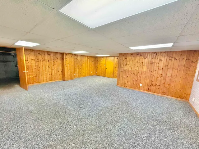 a backyard of a house with plants and large trees