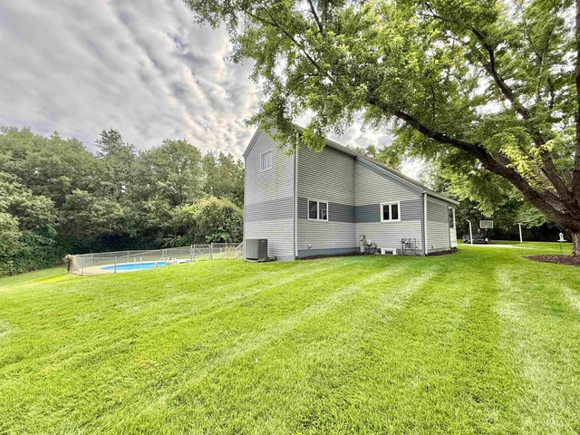an aerial view of a house with a yard and trees all around