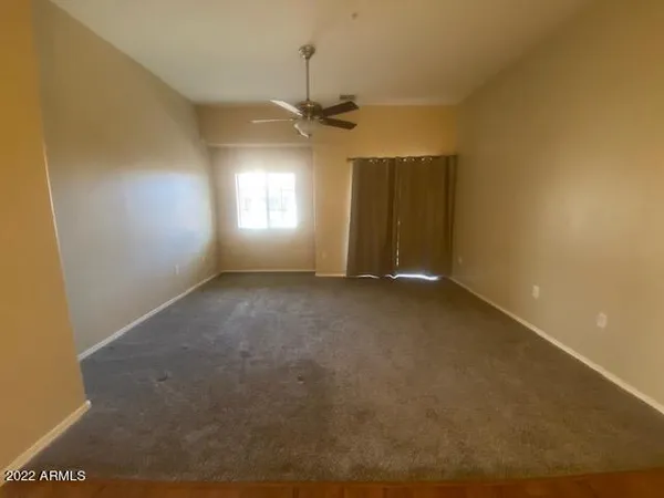 an empty room with a ceiling fan and window