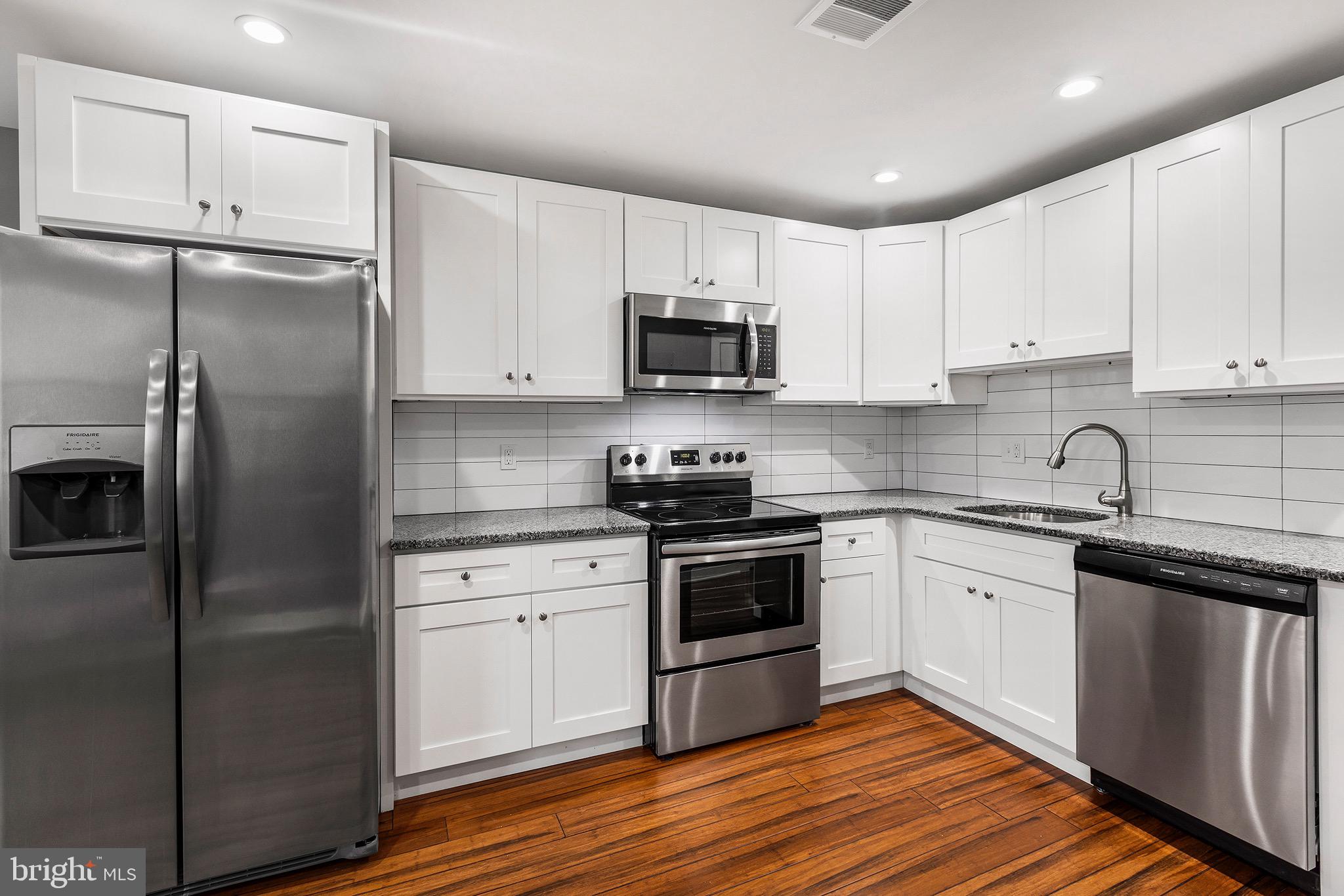 2125 North 20th Street, Unit 2 Philadelphia, PA 19121 - Photo 2 of 20 a kitchen with stainless steel appliances granite countertop a stove a refrigerator and a sink