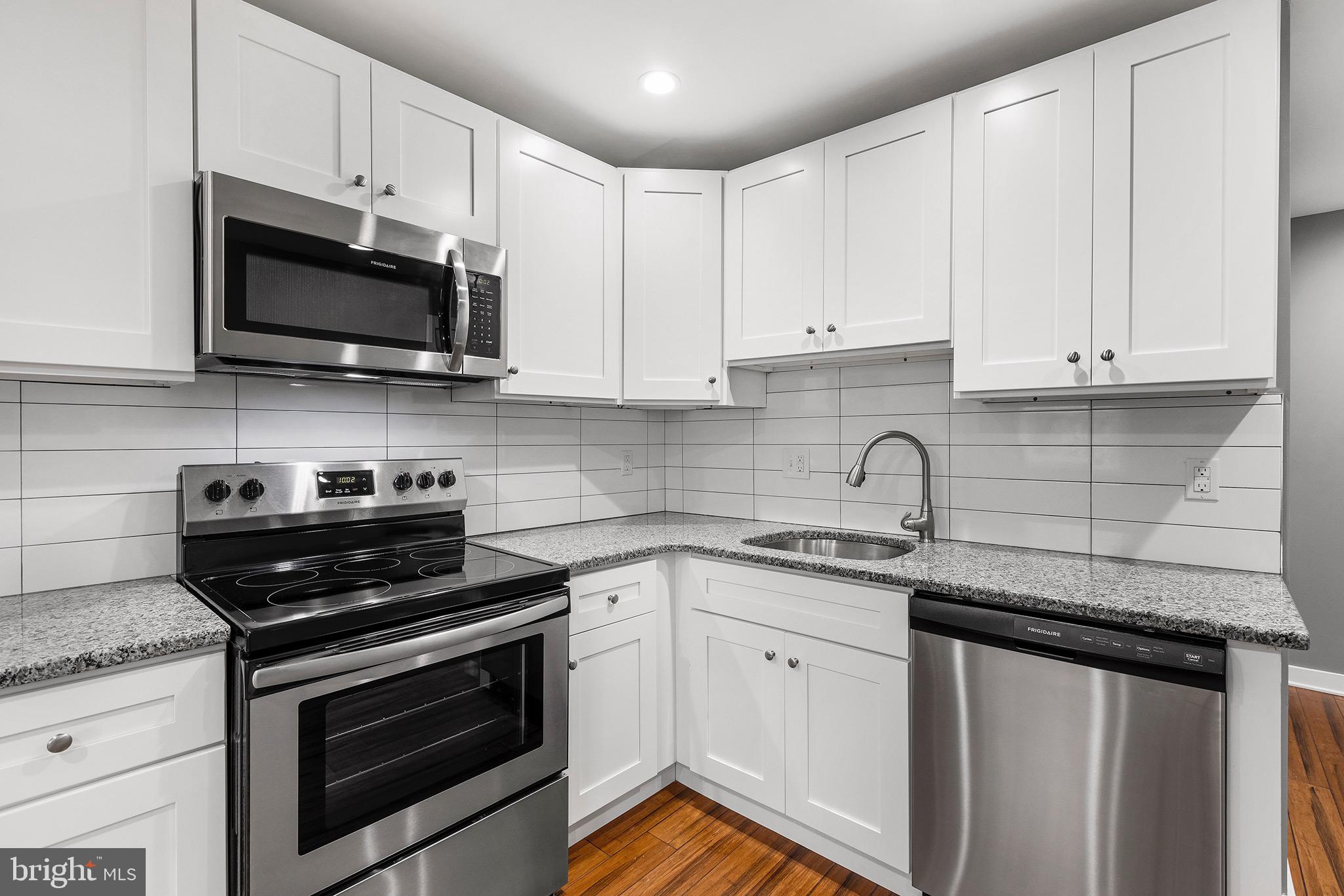 2125 North 20th Street, Unit 2 Philadelphia, PA 19121 - Photo 3 of 20 a kitchen with stainless steel appliances granite countertop grey cabinets a stove a sink and dishwasher