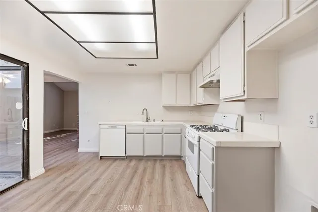 a kitchen with stainless steel appliances a white stove top oven sink and cabinets