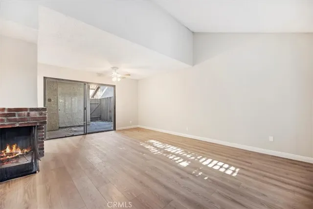 a view of empty room with wooden floor and fireplace