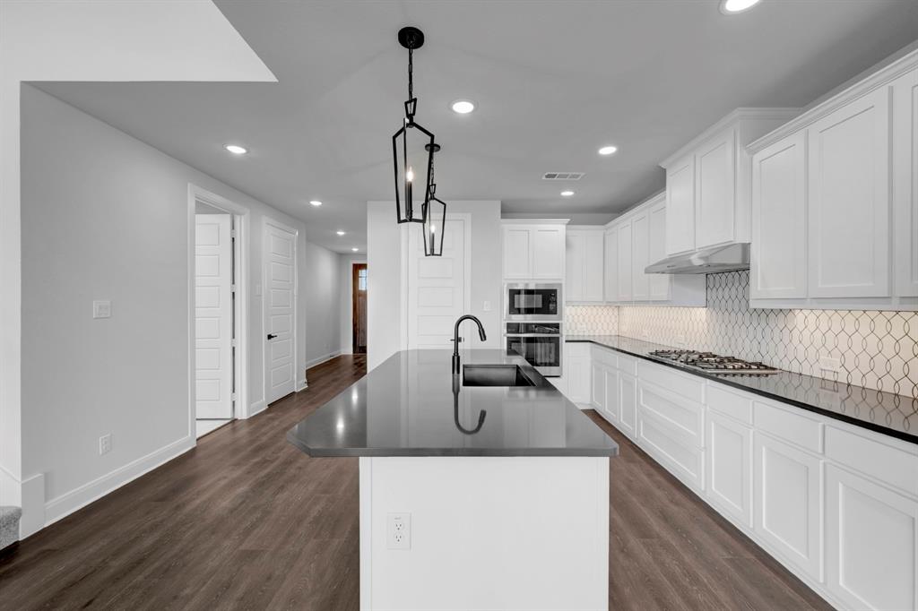 9004 Chestnut Lane Justin, TX 76247 - Photo 19 of 40 a view of a kitchen with kitchen island a sink stainless steel appliances and cabinets