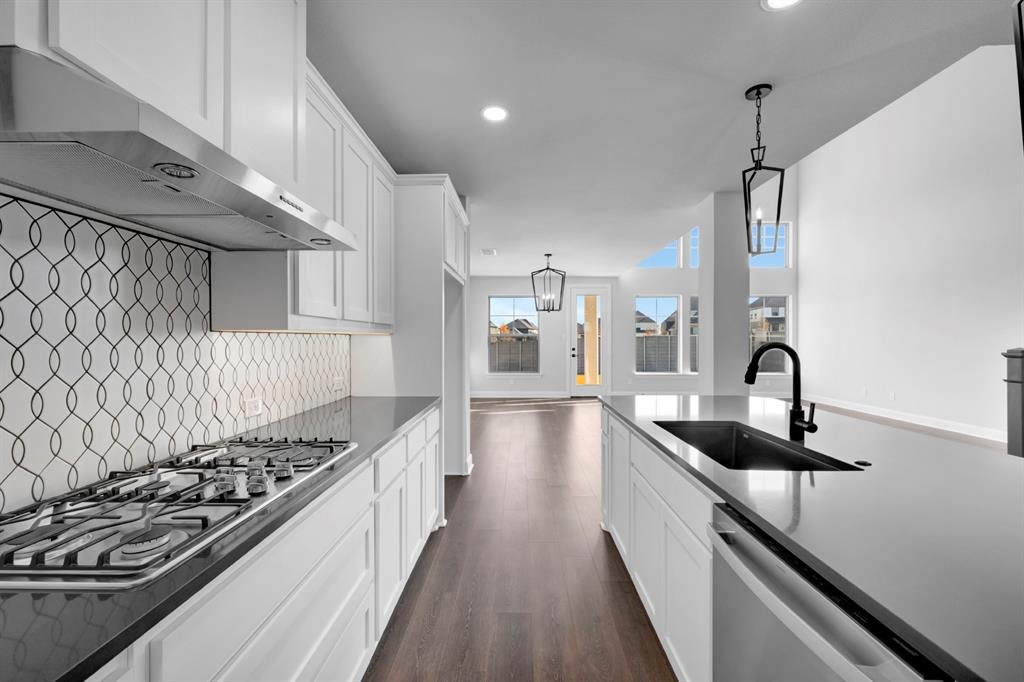 9004 Chestnut Lane Justin, TX 76247 - Photo 21 of 40 a kitchen with kitchen island granite countertop a sink stainless steel appliances and cabinets