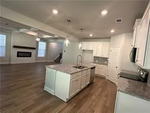 a kitchen with stainless steel appliances granite countertop a stove and a wooden floors
