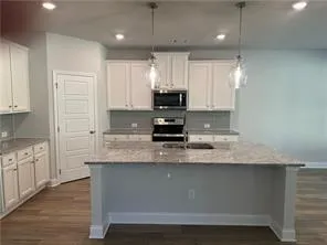 a kitchen with granite countertop a sink a stove and cabinets