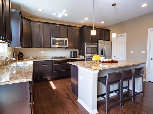 a kitchen with kitchen island granite countertop wooden cabinets and stainless steel appliances