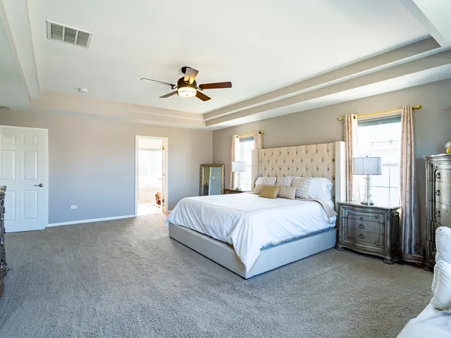 a spacious bedroom with a bed and a chandelier