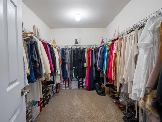 a view of walk in closet with clothes