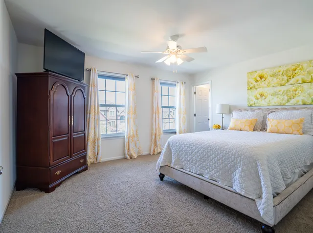 a spacious bedroom with a bed and a chandelier