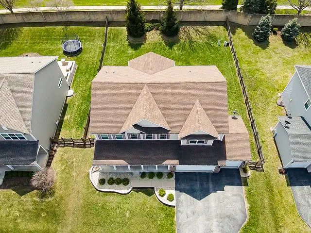 a aerial view of a house with swimming pool and large trees