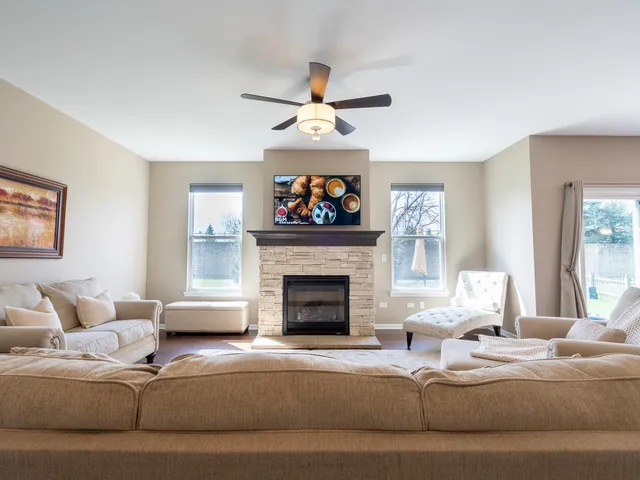 a living room with furniture a fireplace and a chandelier