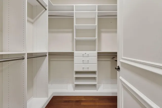 a view of walk in closet with empty racks
