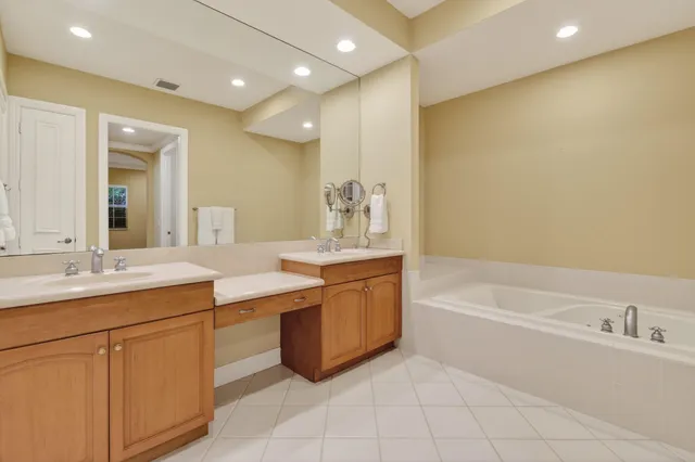 a bathroom with a tub sink and a mirror