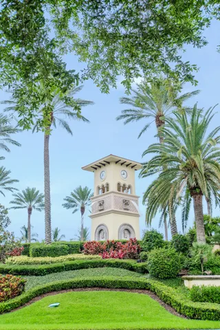 a view of a white house with a big yard and palm trees