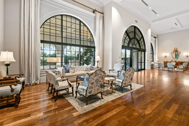 a living room with couches chandelier and a rug