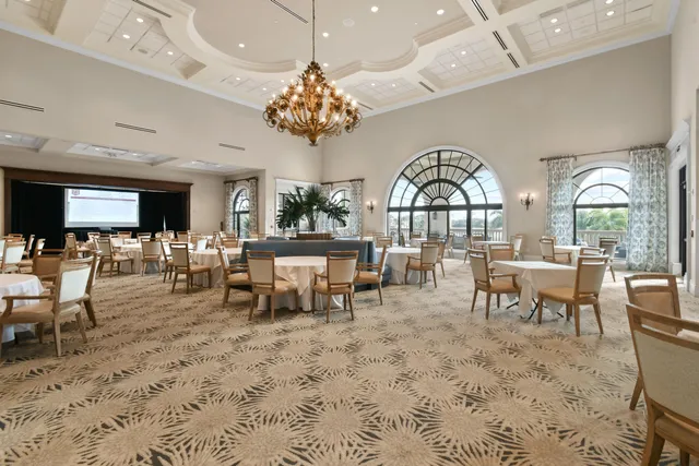 an outdoor space with lots of white furniture and a chandelier