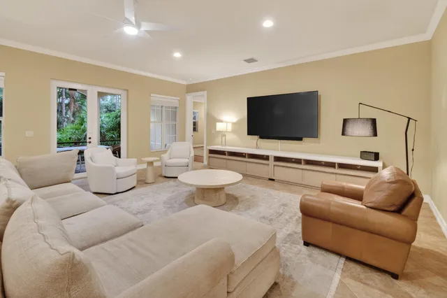a living room with furniture a flat screen tv and a large window