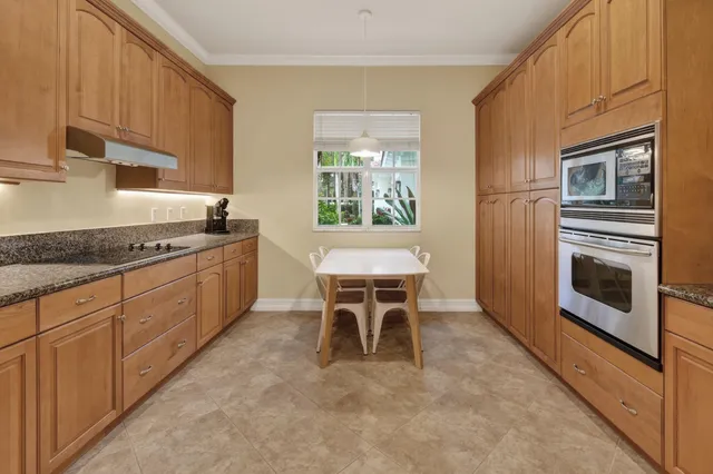 a kitchen with stainless steel appliances granite countertop a stove a sink and a microwave