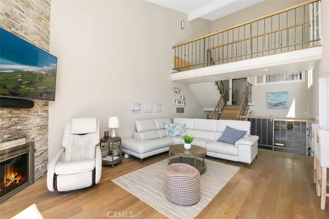 a kitchen with stainless steel appliances granite countertop a refrigerator a sink dishwasher a kitchen island a stove and a refrigerator with wooden floor