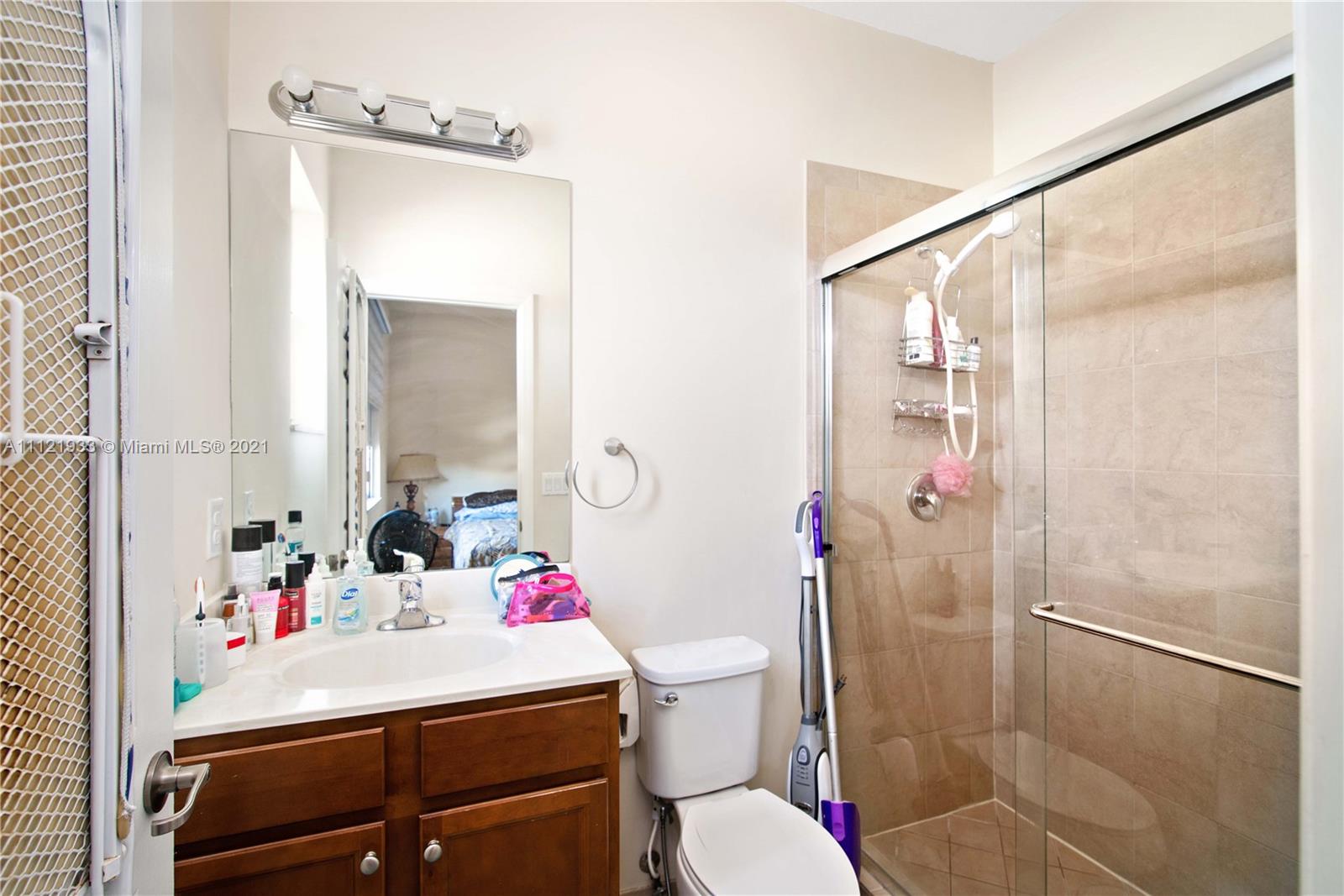 3213 Southeast 5th Court Homestead, FL 33033 - Photo 11 of 19 a bathroom with a sink vanity mirror and toilet