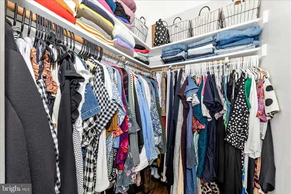 a view of walk in closet with clothes