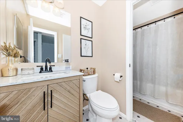 a bathroom with a granite countertop sink mirror vanity and toilet