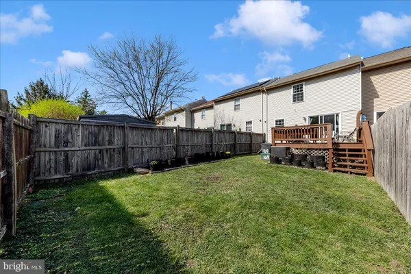 a view of backyard with potted plants and wooden fence