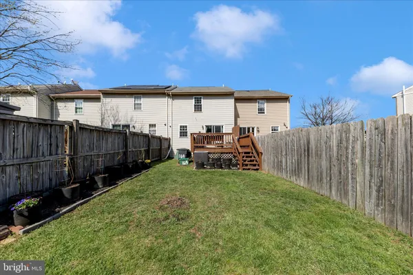 a view of a backyard with wooden fence and a large tree